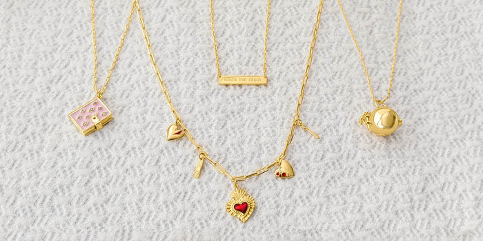 Necklaces and lockets arranged on top of a white background